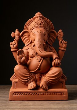 Ganesh chaturthi photo of a detailed terracotta sculpture of lord ganesha, the hindu god of wisdom and prosperity, seated in a meditative pose against a dark background