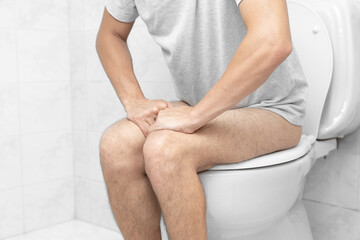Sitting on toilet with suffering from constipation or hemorrhoid. Feels uncomfortable in his...