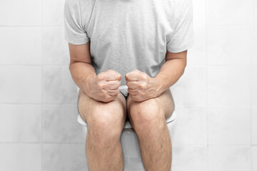 Sitting on toilet with suffering from constipation or hemorrhoid. Feels uncomfortable in his...