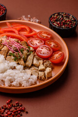 Bowl with chicken pieces, rice, tomatoes, peppers and microgreens. Bowl with chicken