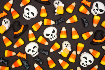 Fototapeta premium Halloween candy background. Top down view flat lay against a black background.