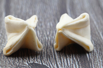 handmade manti (turkish ravioli type dumplings) on wooden background,  before cooking. extreme close up, macro.