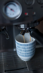 Espresso Coffee Pouring into Cup from Coffee Machine