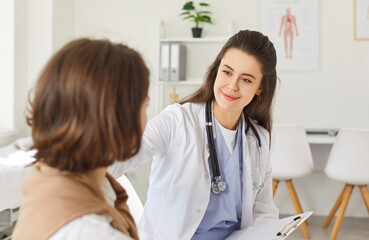 Obraz premium Young female doctor consulting woman patient at appointment in clinic, explaining medical checkup results, giving recommendations at meeting, nurse talking about exam result, helping, support