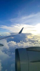 Obraz premium Airplane wing and engine over clouds