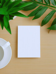 Mockup of a boho invitation card displayed on a minimalist wooden table with plants and a cup