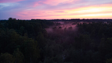 Aerial View of Serene Misty Landscape at Dawn with Vibrant Sunrise