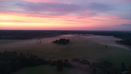 Aerial View of Serene Misty Landscape at Dawn with Vibrant Sunrise