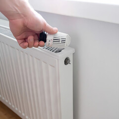 Person adjusting radiator thermostat