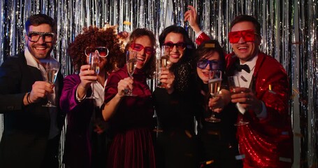 Happy cheerful business team people in suits dancing together celebrating success at corporate party indoors holding champagne glasses. Young friends group having fun at disco. 4k video.
