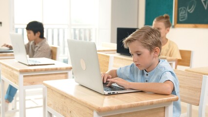 Caucasian smart child programing software system and learning about coding while multicultural...