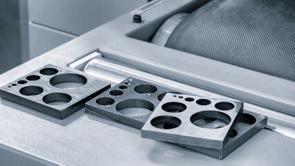 metal pieces are being cut by machine. pieces all same size and shape, and they are arranged in a...