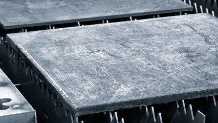 metal sheet is placed on the surface. plate is made of metal and has a rough texture. It is placed...