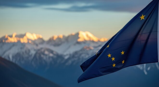 Close up view of the alaska state flag with mountain range in the background at sunrise. Concept for patriotism, travel and state pride.