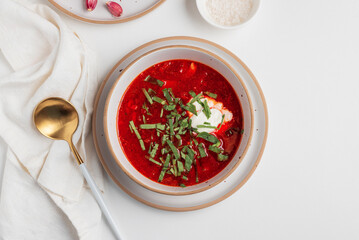 Traditional Ukrainian borscht with sour cream, garlic and rye bread on white table. Top view