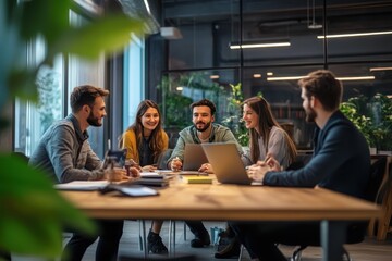 Diverse team collaborates around a table with laptops