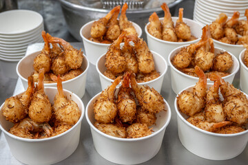Paper cups holding crispy, golden fried shrimp. Shrimp is a popular ingredient throughout Korea and...