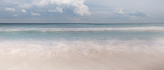 ocean is calm and the sky is blue. The water is a beautiful shade of green. The scene is peaceful and serene, vacation travel concept.