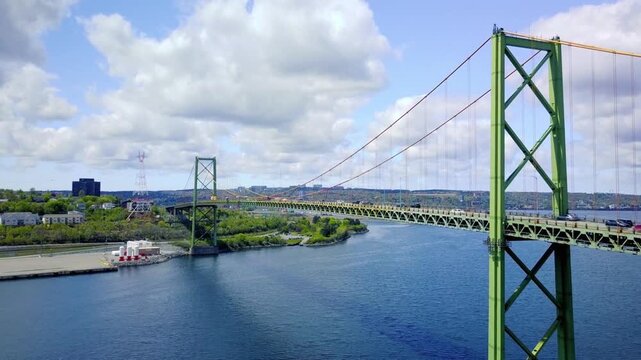 The angus l macdonald bridge in halifax, nova scotia on a sunny day with clouds