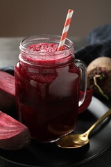 Superfood. Refreshing smoothie in mason jar and beetroots on grey table against brown background, closeup