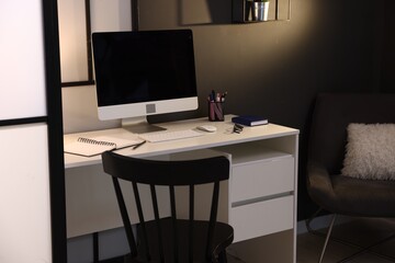 Stylish workplace with desk, computer and stationery at home office. Interior design