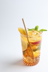 Tasty iced tea with lemon, peach and mint on white background, closeup