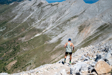 Man trail running in rocky mountains . Adventure activity outdoor .Skyrunning extreme sport concept