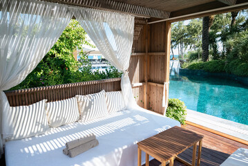 Luxury Loungers with white curtains and pool view 