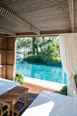 Luxury Loungers with white curtains and pool view 