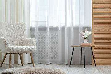 Stylish furniture near window with curtains in living room. Interior design