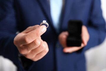 Making proposal. Man with engagement ring indoors, closeup