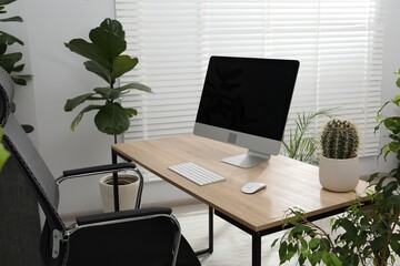 Biophilic interior design. Stylish workplace with computer and houseplants in office