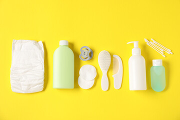 Baby accessories and cosmetic products on yellow background, flat lay