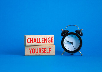 Challenge yourself symbol. Wooden blocks with words Challenge yourself. Beautiful blue background...