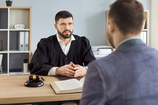 Judge, law professional solicitor or barrister, attorney in court of law talking to client, accuse guilty, proclamation, passes judgment for final decision, result, gavel wooden hammer at desk 