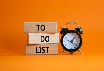 To Do List symbol. Concept words To Do List on wooden blocks. Beautiful orange background with...