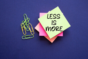 Less is More symbol. Sticky Notes with Concept words Less is More. Beautiful deep blue background....
