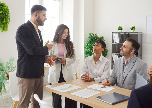 Diverse joyful people chatting on business meeting. Company employees talking in office and making great decisions with brainstorming, discussing new projects at the working place. Teamwork concept. - Powered by Adobe