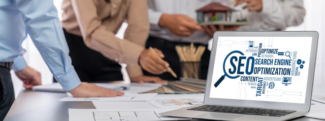 Group of interior architect designer discussing together on blueprint and laptop screen display...