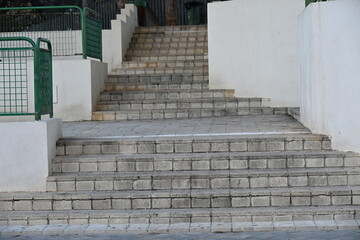 betonowe schody z zieloną barierką puste