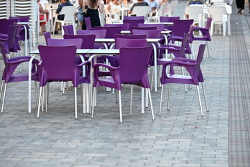 puste fioletowe krzesła i białe stopy w ogródku restauracyjnym