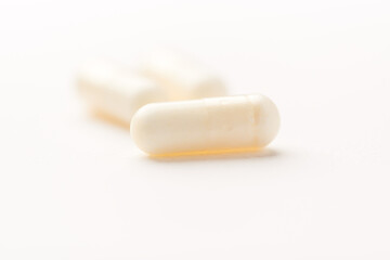 Creatine capsules on paper background. Soft focus. Close up. Copy space.	