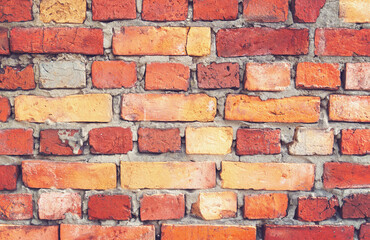 Background of uneven bricks of different sizes with cement joints. Texture close-up.