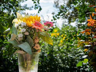 vibrant bouquet of fresh flowers in a glass vase with a lush green garden background