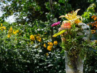 vibrant bouquet of fresh flowers in a glass vase with a lush green garden background