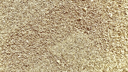 golden beige gravel surface with rough small stone texture under sunlight ideal for natural background or construction material design