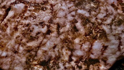 polished rose quartz slab with earthy mineral veins and glossy marbling ideal for gemstone texture background or crystal healing art