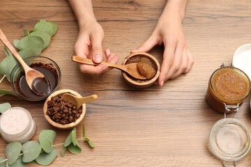 Woman making natural body scrub at wooden table, top view
