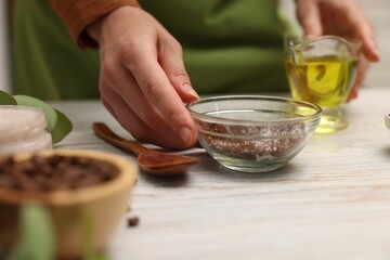 Woman making natural body scrub at white wooden table, closeup