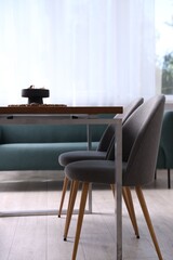 Wooden table with chairs and decor in dining room. Interior design